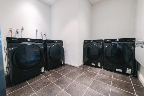 three washing machines are in a laundry room at Best Western Plus Jeonju in Jeonju