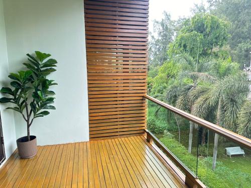 a balcony with a large window and a plant at The Bihai Hua Hin in Hua Hin