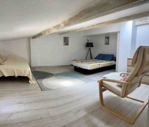 une chambre avec un lit et une chaise dans une pièce dans l'établissement Maison Bages d'Aude proche étang, à Bages