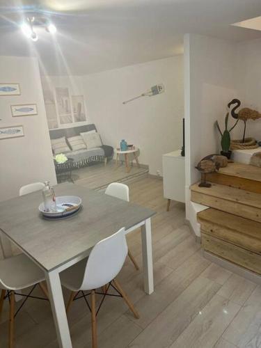 un salon avec une table et des chaises blanches dans l'établissement Maison Bages d'Aude proche étang, à Bages