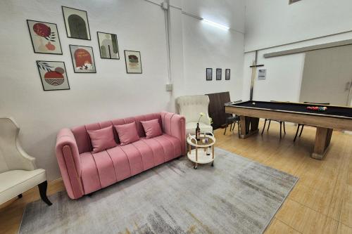 a living room with a pink couch and a pool table at Townhouse at Yaek Lam Sali station for 6 pax in Ban Bang Toei (1)