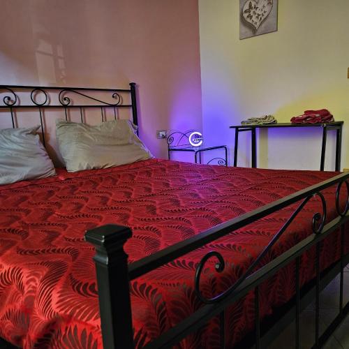a bedroom with a bed with a red comforter at Licheni house in Rome