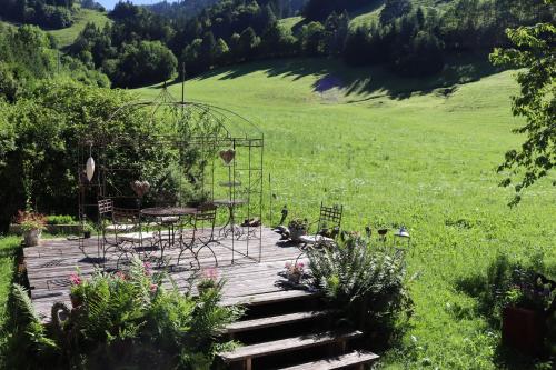 a wooden deck with chairs and a garden in a field at La Reine des Prés in La Tine