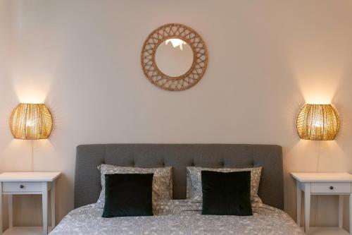 a bedroom with a bed with two lamps and a mirror at Central Charm - 2BR Apartment in Timişoara