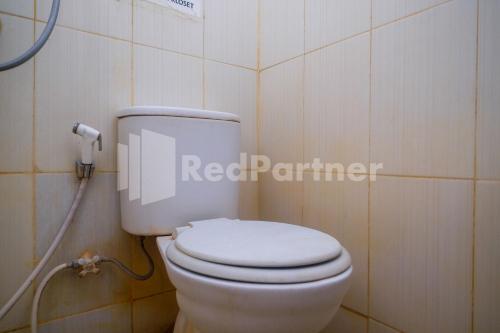 a bathroom with a white toilet in a room at Griya Jasmine Syariah Seturan RedPartner in Yogyakarta