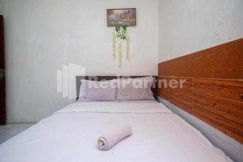 a bedroom with a bed with a roll on it at Griya Jasmine Syariah Seturan RedPartner in Yogyakarta