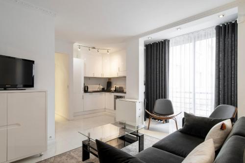 un salon avec un canapé et une cuisine dans l'établissement REF 1380 - Cannes Croisette - Apartment for rent, à Cannes