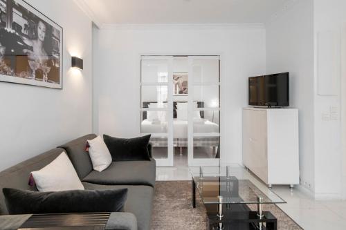 un salon avec un canapé et une télévision dans l'établissement REF 1380 - Cannes Croisette - Apartment for rent, à Cannes