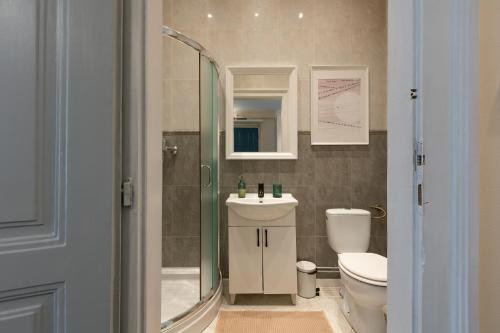 a bathroom with a shower and a toilet and a sink at Central Charm - 2BR Apartment in Timişoara