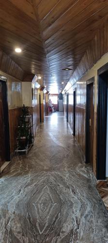 an empty hallway with a floor covered in marble at Hotel Assembly in Shillong