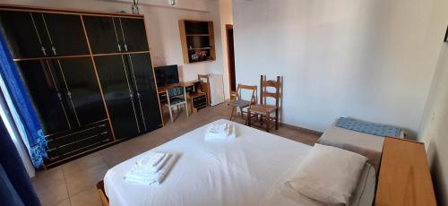 a bedroom with a white bed and a television at Nurache in Orosei