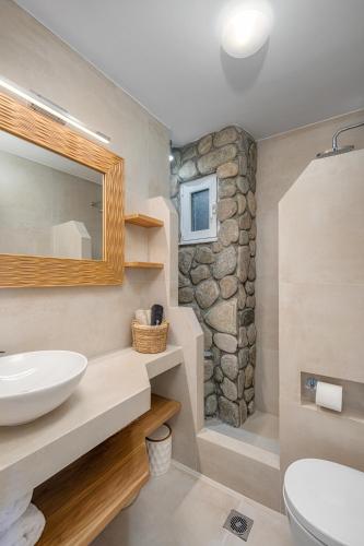 a bathroom with a sink and a mirror at Perla's Luxury Apartments in Livadi