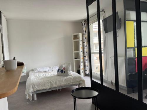 Cette chambre comprend un lit, une table et des fenêtres. dans l'établissement A l'Atelier Montplaisir, à Lyon