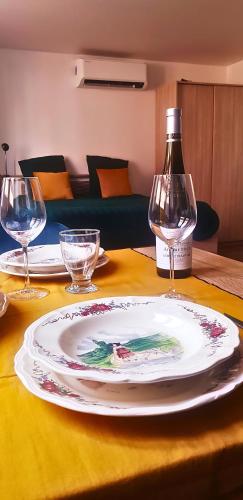 une table avec une assiette et une bouteille de vin dans l'établissement Un studio dans maison familiale, à Nordheim