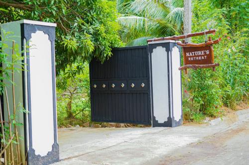 a black gate with a sign in front of it at Nature's Retreat in Dambulla