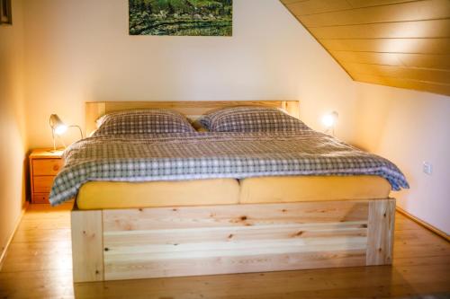 a bedroom with a wooden bed with two lamps at Chalet Horní Orlice in Červená Voda