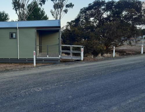 a green building with a gate next to a road at Minyip Caravan Park in Minyip