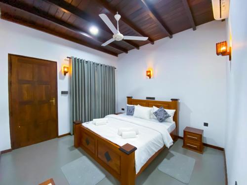 a bedroom with a large bed and a ceiling fan at Nature's Retreat in Dambulla