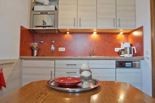 a kitchen with a wooden table with a bowl on it at Haus Obermaiselstein in Obermaiselstein