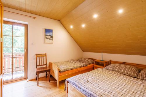 a bedroom with two beds and a window at Chalet Horní Orlice in Červená Voda