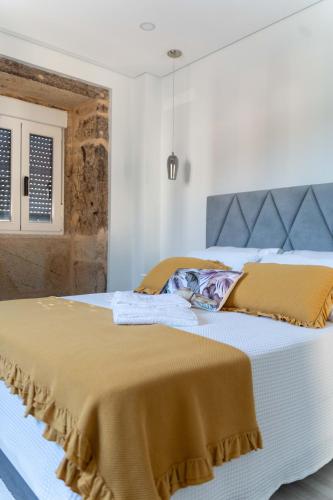 a bedroom with a bed with a blanket on it at Guest House Taião in Valença