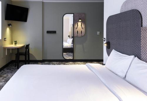 a hotel room with a bed and a mirror at B&B HOTEL Toulouse Cité de l'Espace Gonord in Toulouse