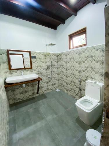 a bathroom with a toilet and a sink at Nature's Retreat in Dambulla
