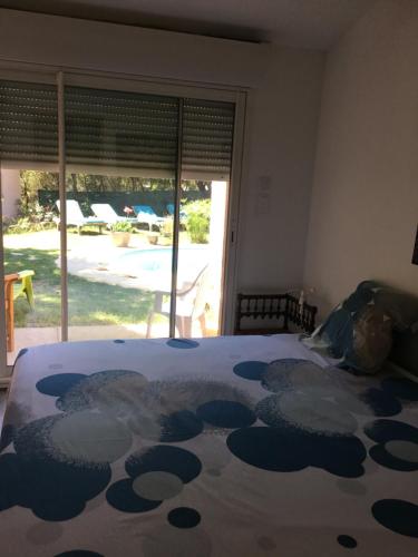 une chambre avec un lit et une grande fenêtre dans l'établissement MAISON FAMILIALE, à Montaren-et-Saint-Médiers