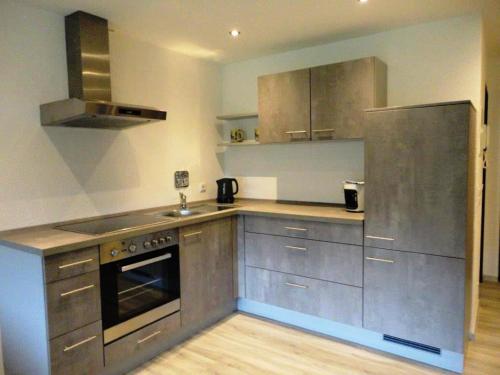 a kitchen with stainless steel cabinets and a refrigerator at Haus Obermaiselstein in Obermaiselstein