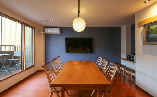 Un comedor con mesa y sillas de madera. en Takayamaan 高山駅徒歩3分 古い町並み徒歩5分のベストロケーション 2バスルーム3寝室で広々快適, en Takayama