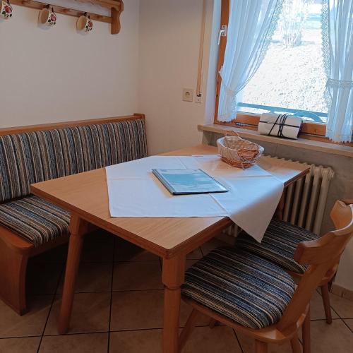 a wooden table with two chairs and a book on it at Haus Obermaiselstein in Obermaiselstein