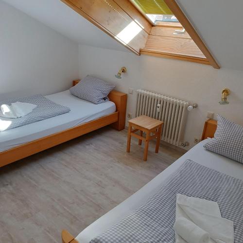 a small bedroom with two beds and a skylight at Haus Obermaiselstein in Obermaiselstein