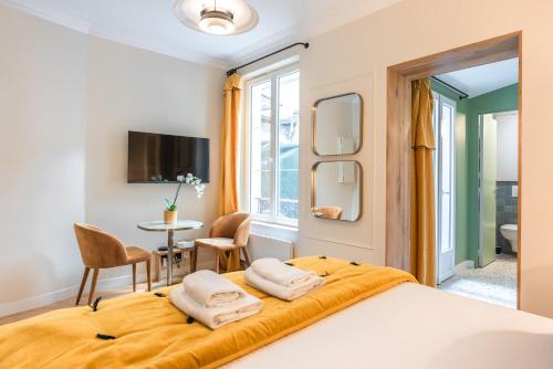 - une chambre avec un grand lit et 2 serviettes blanches dans l'établissement Charming Studio with terrace - Near Montmartre, à Paris