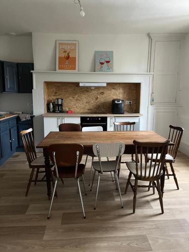 une cuisine avec une table et des chaises en bois dans l'établissement Jolie maison traditionnelle, à Allassac