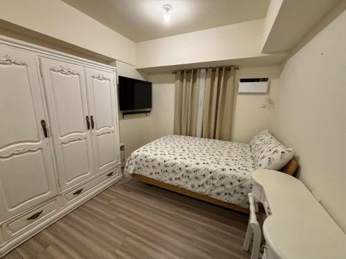 a small bedroom with a bed and a tv at Avida Towers Riala Tower 4 in Cebu City