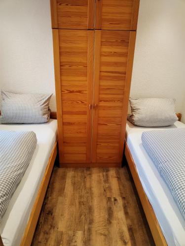 two beds in a room with a closet at Haus Obermaiselstein in Obermaiselstein