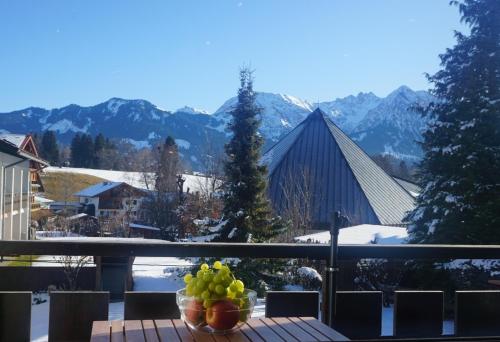 a bowl of fruit on a table on a balcony at Haus Obermaiselstein in Obermaiselstein