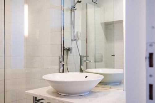 a white bathroom with a sink and a shower at Gästehaus Klinglhuber in Krems an der Donau