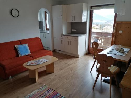 a living room with a couch and a table at Embacher Marianne - Rotharlhof in Hopfgarten im Brixental