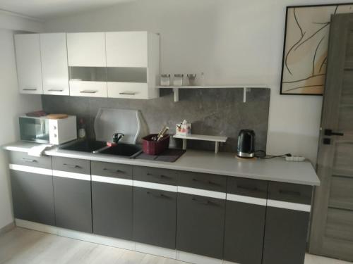 kuchnia z białymi szafkami i blatem w obiekcie WOLSKA APARTMENT 80m2 - 7 people, 3 rooms we Wrocławiu