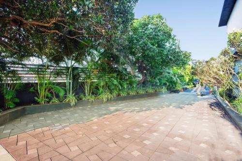 a brick walkway with trees and plants on it at Crystal Village in Nagoa-Bardez