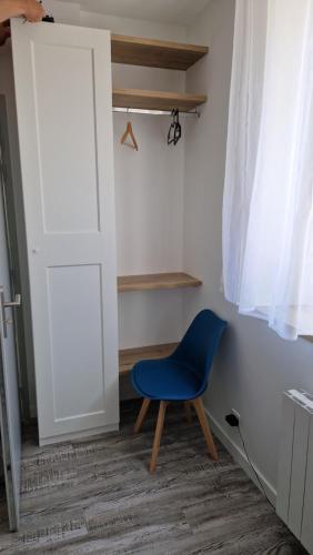une chaise bleue assise devant une porte dans l'établissement Appartement DMV, à Longaulnay