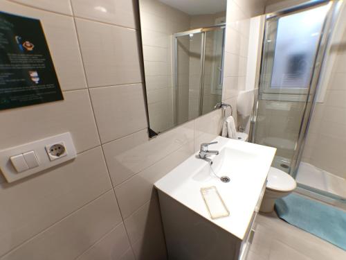 a bathroom with a sink and a mirror and a toilet at Pensión La Estación in Logroño