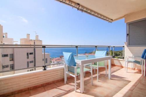 a balcony with a table and chairs and a view of the ocean at Apartamento con piscina - Plazamayor 251 in Calpe