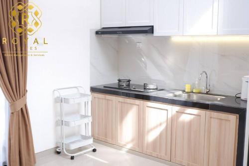 a kitchen with white cabinets and a sink at Royal Suites Home Villa 3BR with Private Pool - C9 in Batam Center