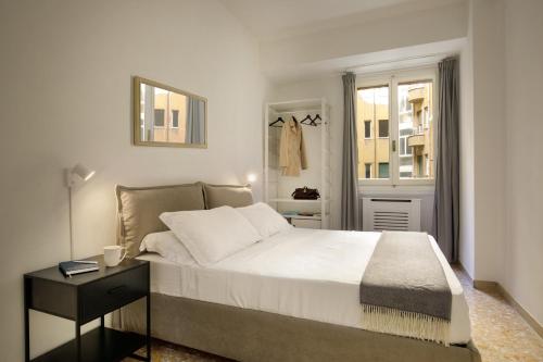a white bedroom with a bed and a mirror at The Right Place 4U Piemonte Apartment in Rome