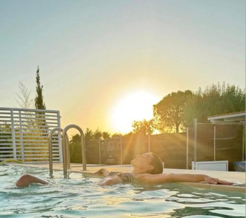 a young woman in a swimming pool with the sun setting at 87029house in Scalea