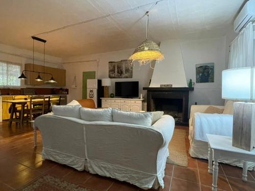 a living room with a white couch and a table at Casa Rural las Tres Rosas in Gaucín