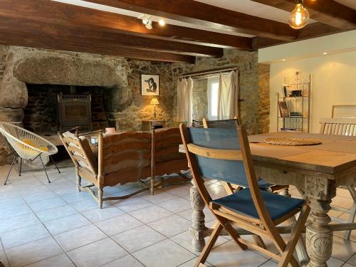 une salle à manger avec une table et une cheminée dans l'établissement Maison de caractère à 3km de la mer, à Porspoder