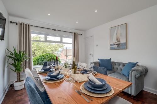 a living room with a wooden table and blue chairs at Stunning Home over Belfast City 11 minutes to Belfast City Centre in Belfast